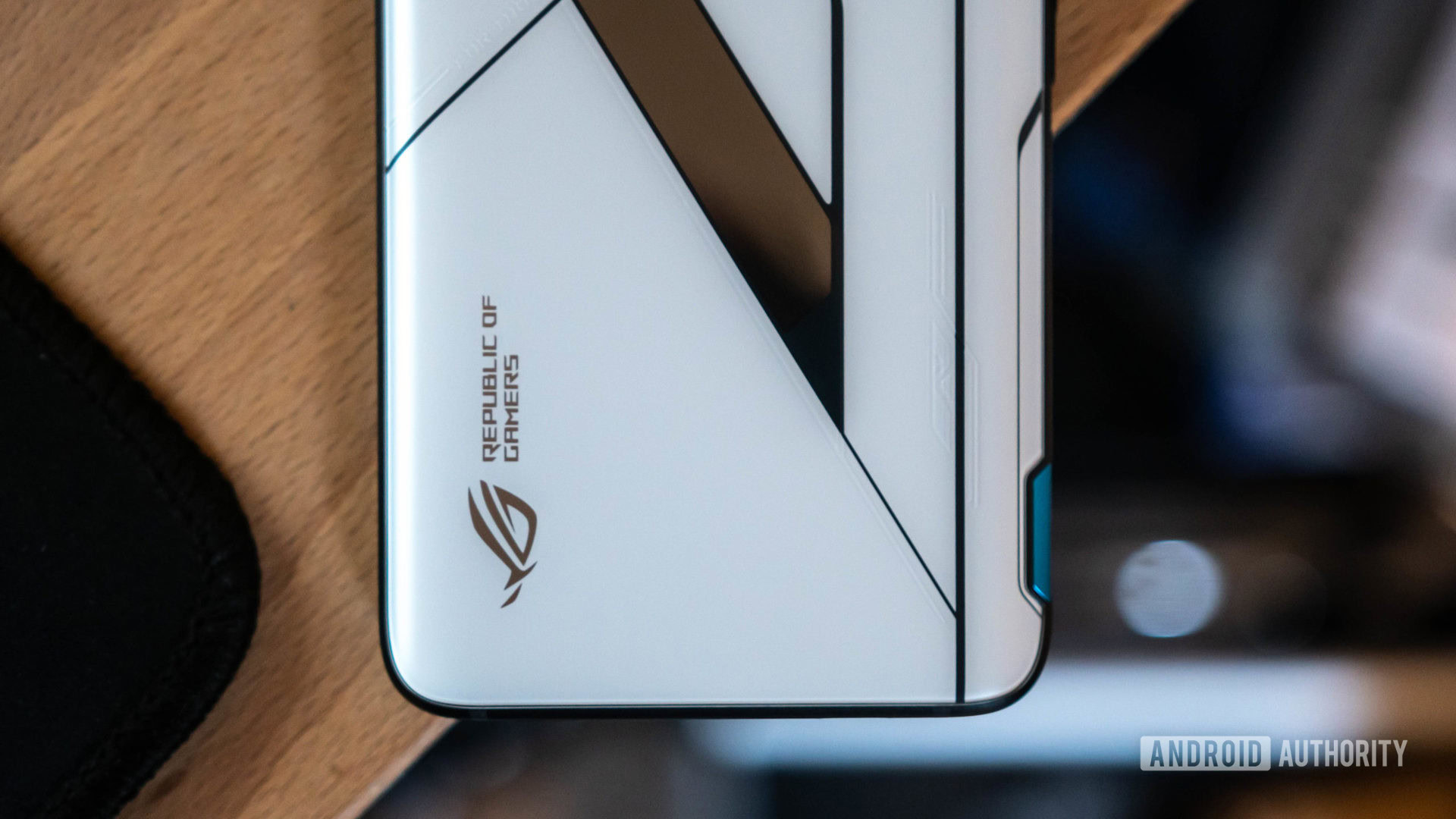 The Asus ROG Phone 5 Ultimate Edition is under the phone, close up