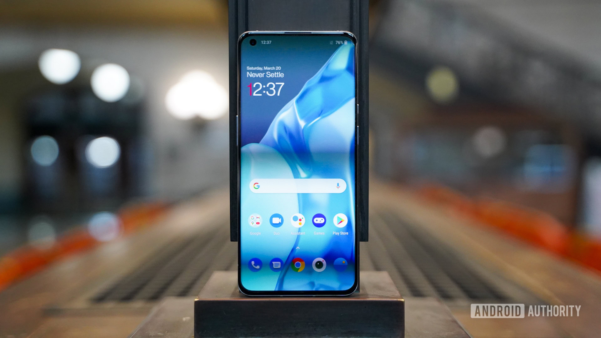The OnePlus 9 Pro standing tall showing the screen and apps.
