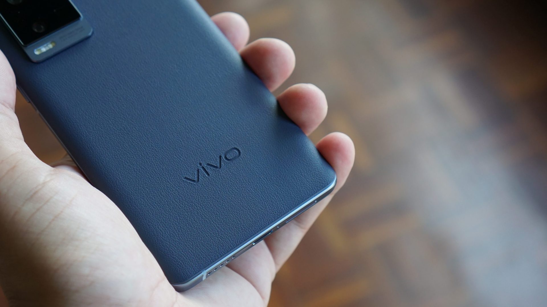 Vivo X60 Pro Plus in hand showing logo and rear of phone