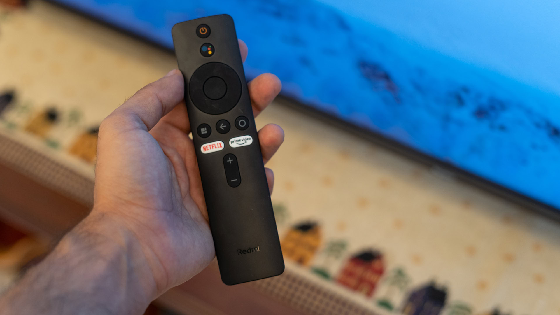 Xiaomi Redmi X65 TV remote in hand