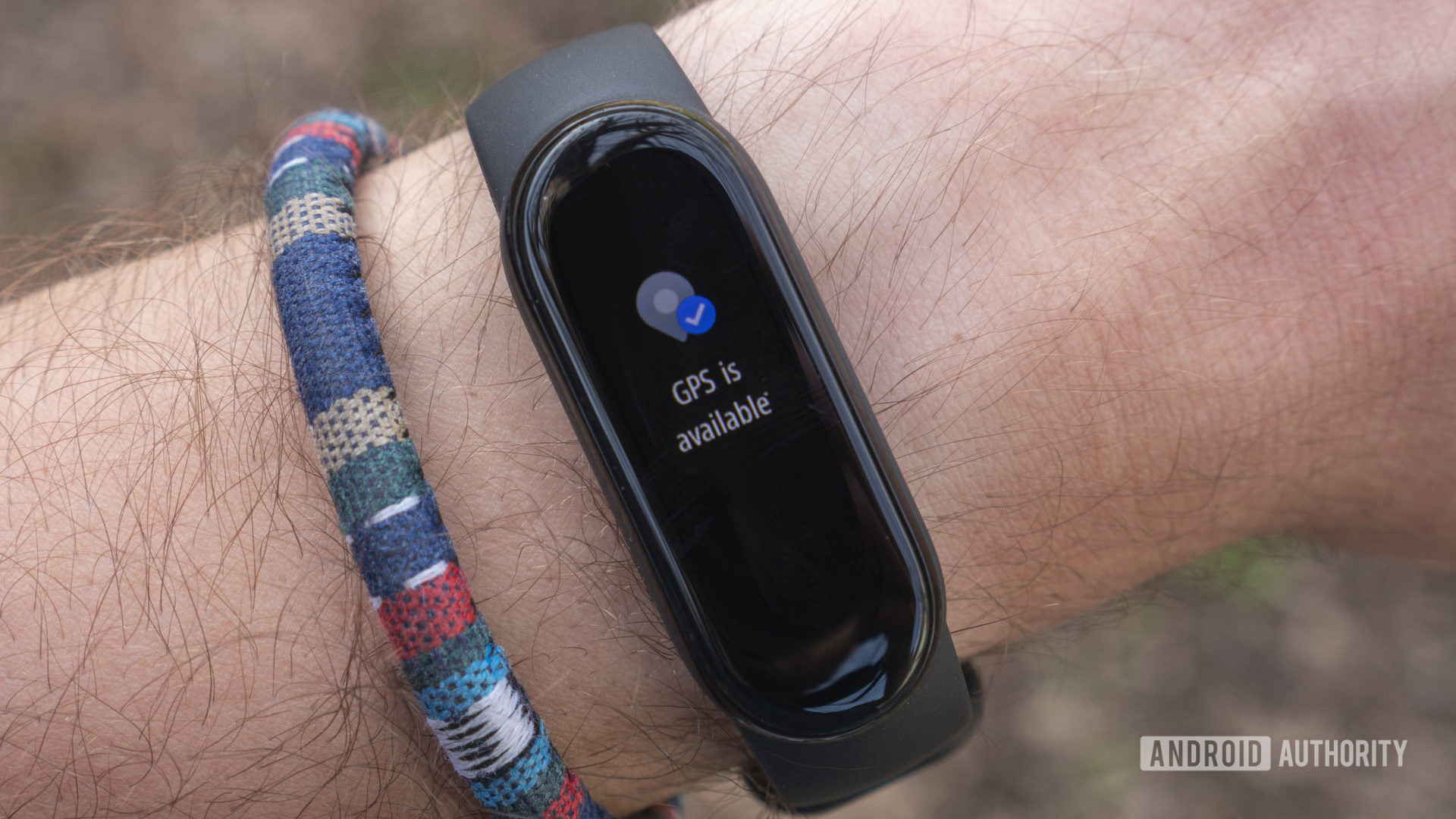 A Xiaomi Mi Band 6 on a user's wrist display GPS as available.