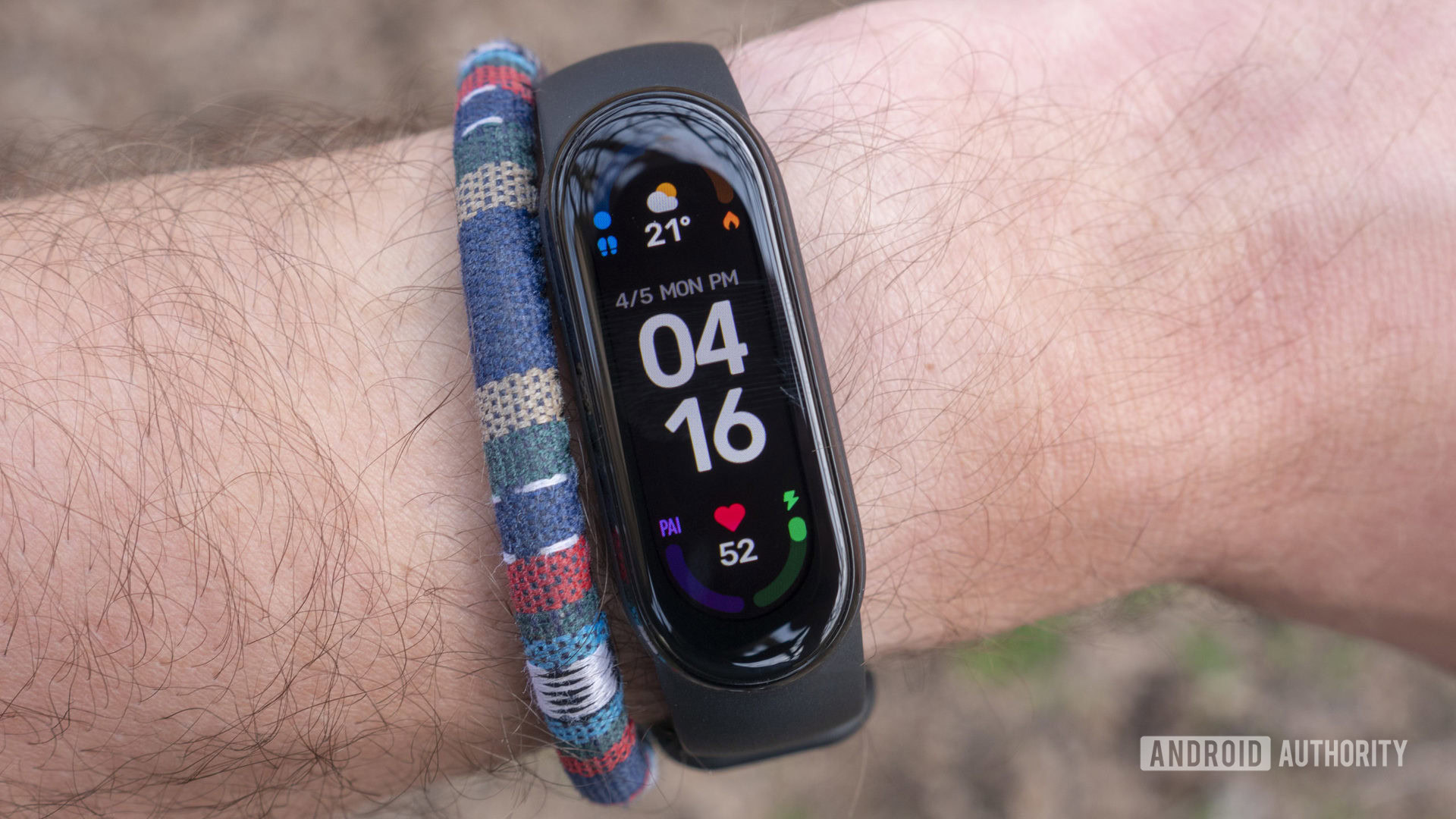 Xiaomi Mi Band 6 displays the device watch face on a user's wrist.