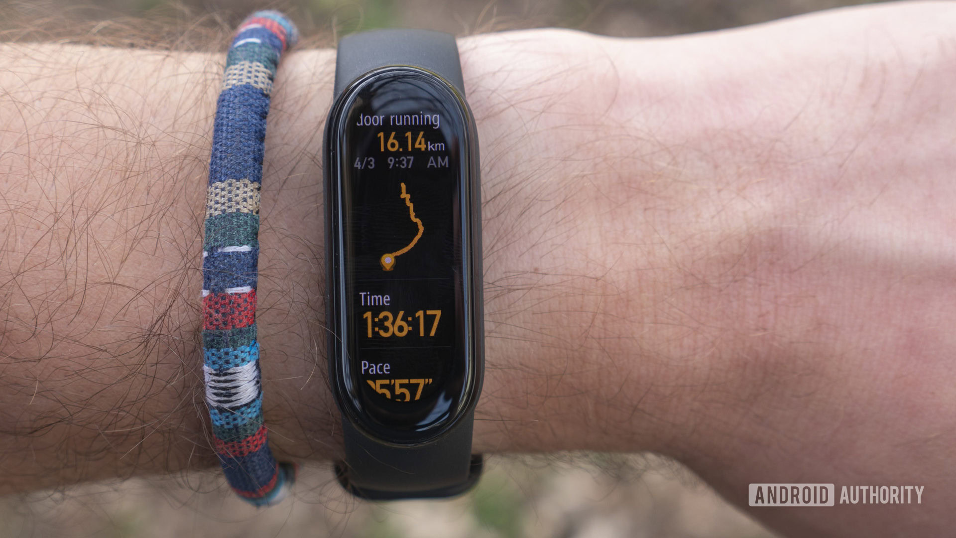 A Xiaomi Mi Band 6 on a user's wrist displays the device's running workout summary page.