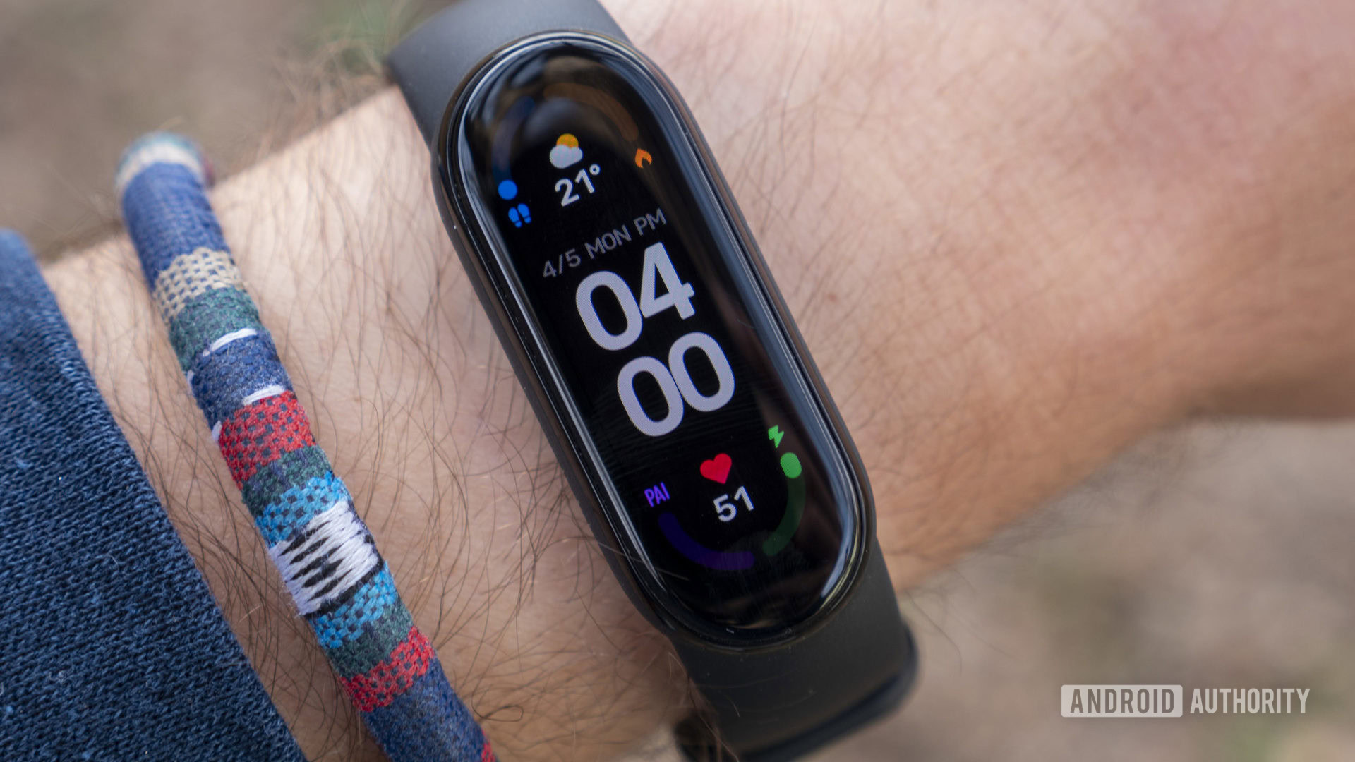 A Xiaomi Mi Band 6 displays the time and other metrics on a user's wrist.