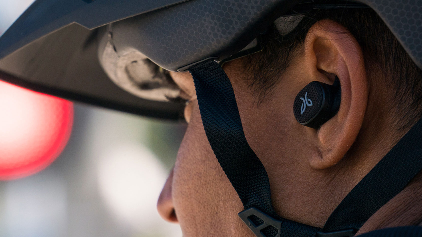A man wears the Jaybird Vista 2 true wireless workout earbuds while cycling.