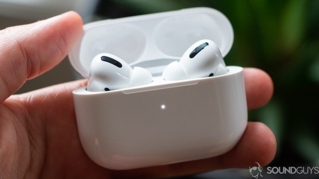 The AirPods Pro (1st generation) in their case with the lid open being held by a hand.