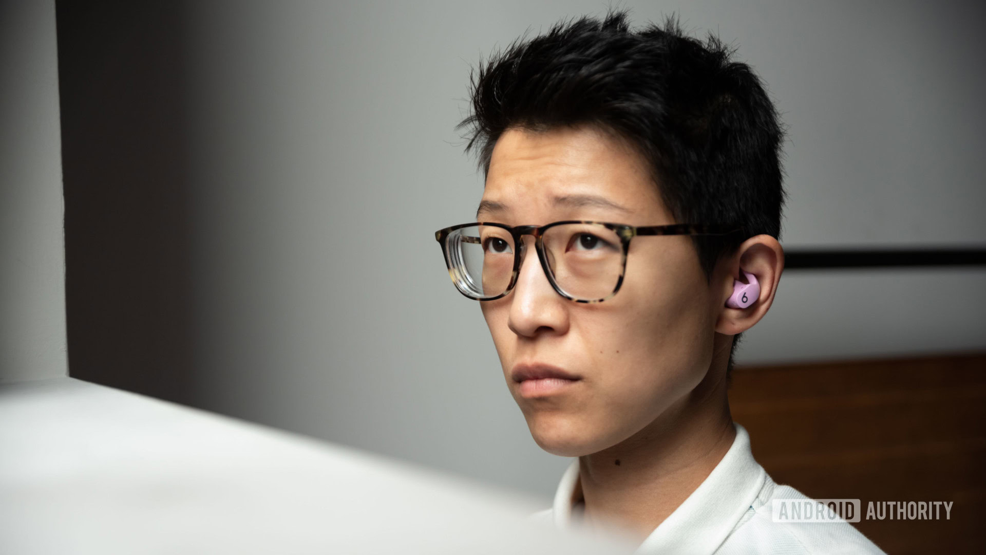 A woman wears the Beats Fit Pro noise cancelling true wireless earbuds in purple.