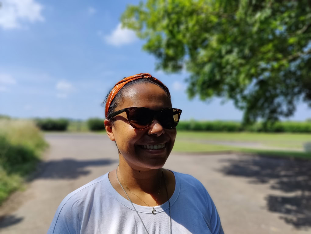 Portrait of dark skinned woman with blue skies shot on OnePlus 9 Pro