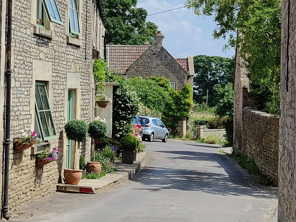 100% crop of stone houses on a paved street Picture of road and sky OnePlus 9 Pro