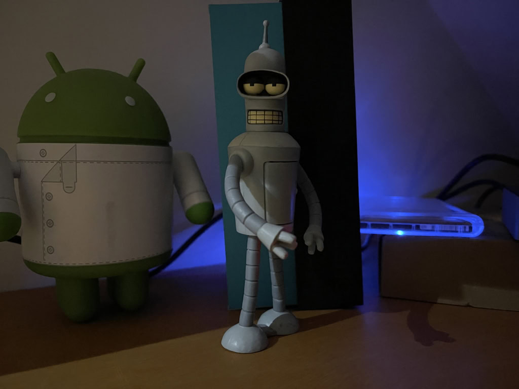 Android and Bender figurines in the dark taken on Apple iPhone 12 Pro Max