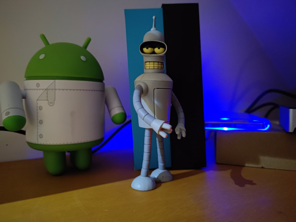 Android and Bender figurines in the dark taken on OnePlus 9 Pro