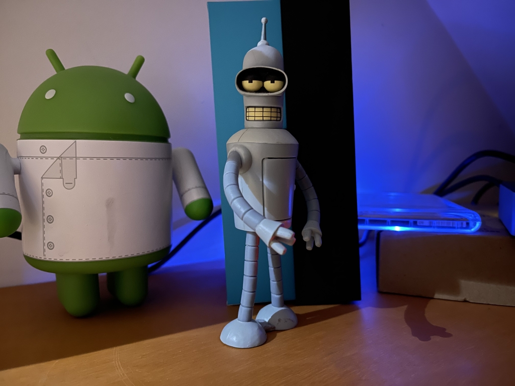 Android and Bender figurines in the dark taken on Apple iPhone 12 Pro Max