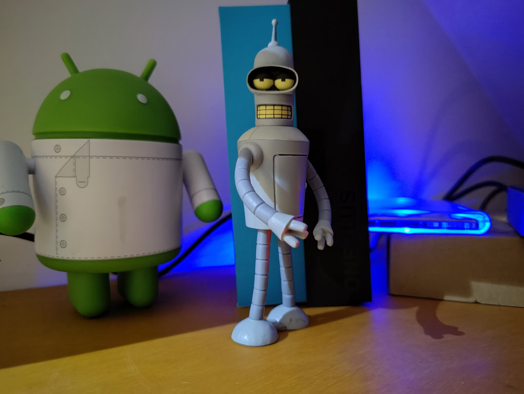 Android and Bender figurines in the dark taken on OnePlus 9 Pro