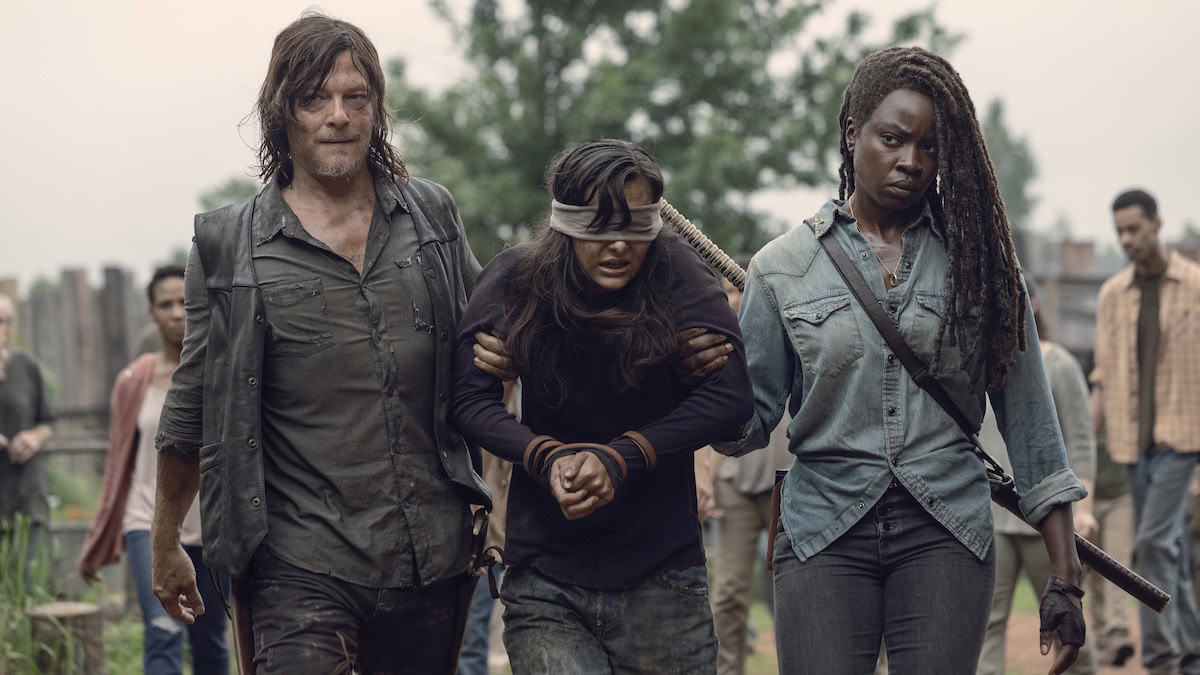 Danai Gurira as Michonne and Norman Reedus as Daryl Dixon escort a prisoner in The Walking Dead