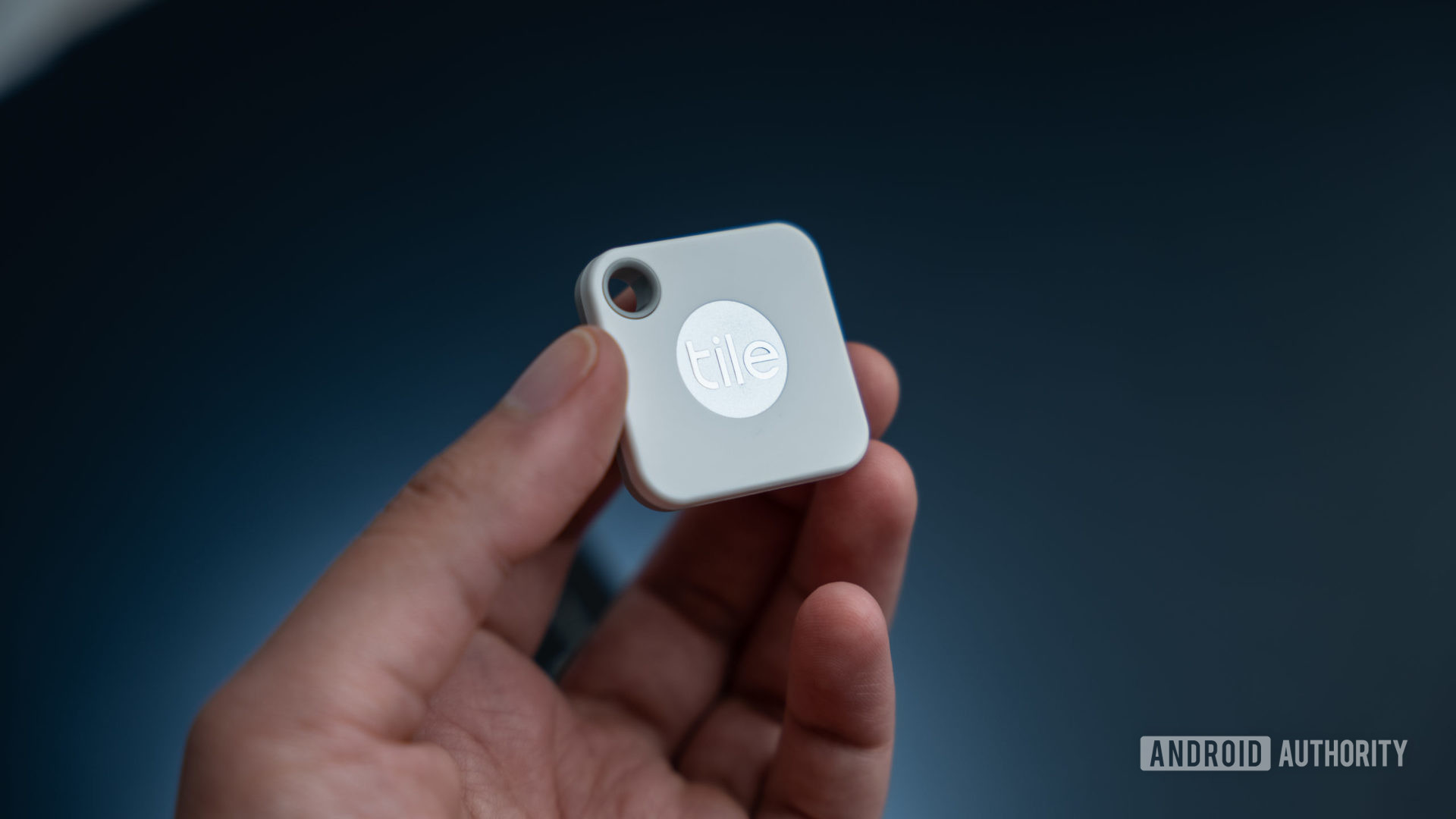 The Tile Mate Tracker in hand showing the Tile logo.
