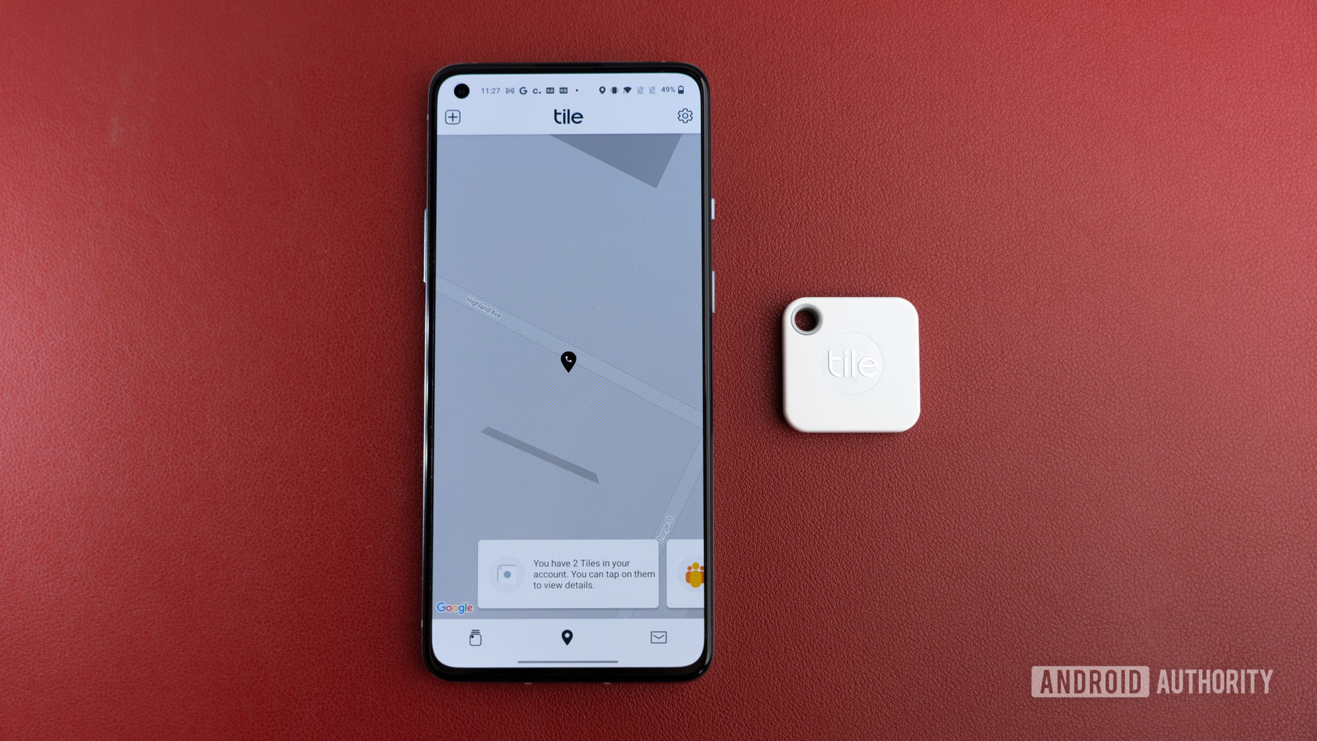 The Tile Mate Tracker next to a phone.