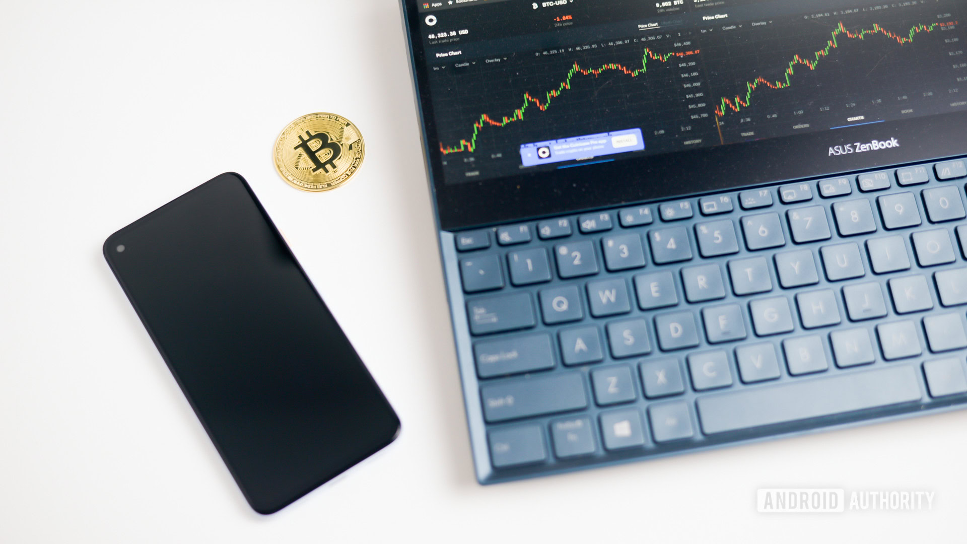 Bitcoin coin next to laptop with graphs stock image