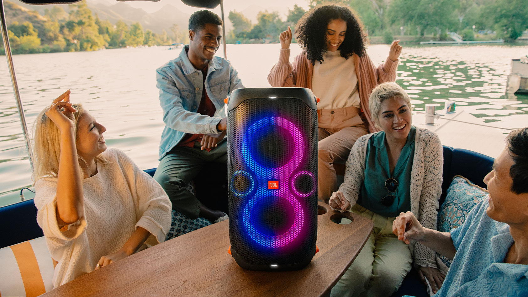 The JBL Partybox 110 sits front and center as a group of friends party on a boat.