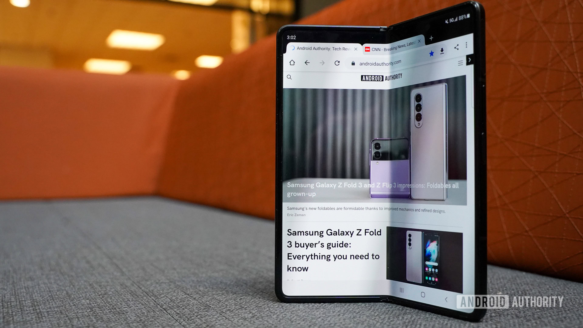 Samsung Galaxy Z Fold 3 abierto mostrando la pantalla interna en un sofá.