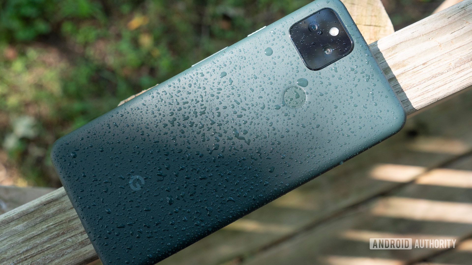 Google Pixel 5a is splashed on a bench with water droplets