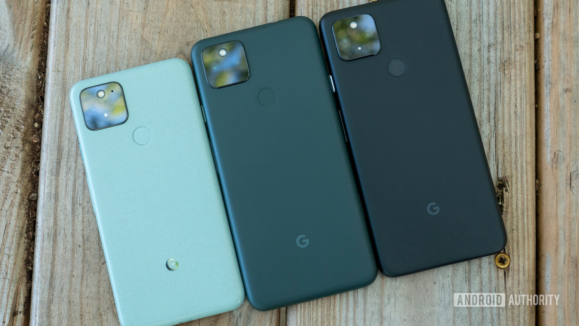 the google pixel 5a on a bench compared to the pixel 5 and pixel 4a 5g with back panels showing
