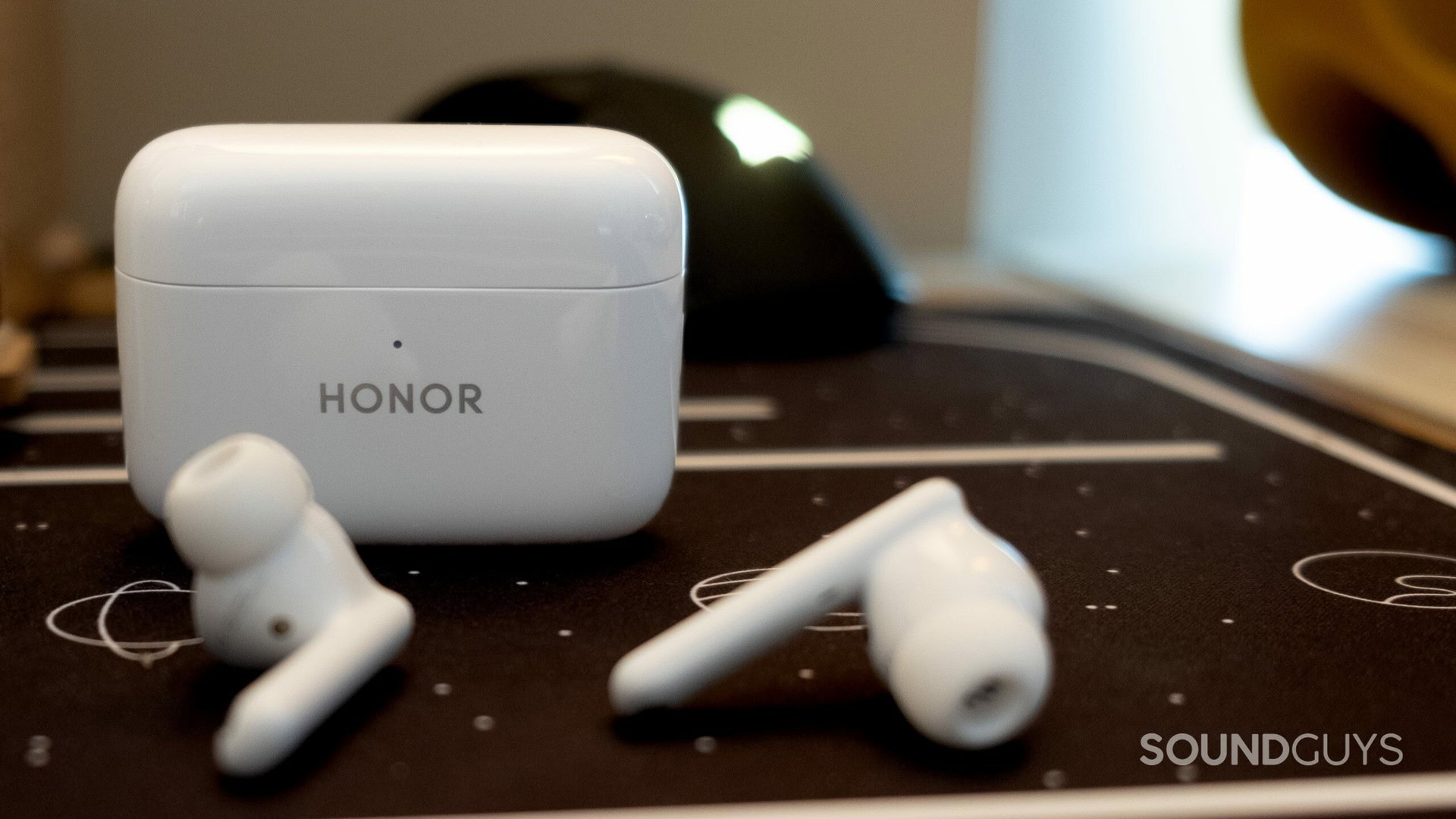 An image of the Honor Earbuds 2 Lite charging case standing behind the earbuds