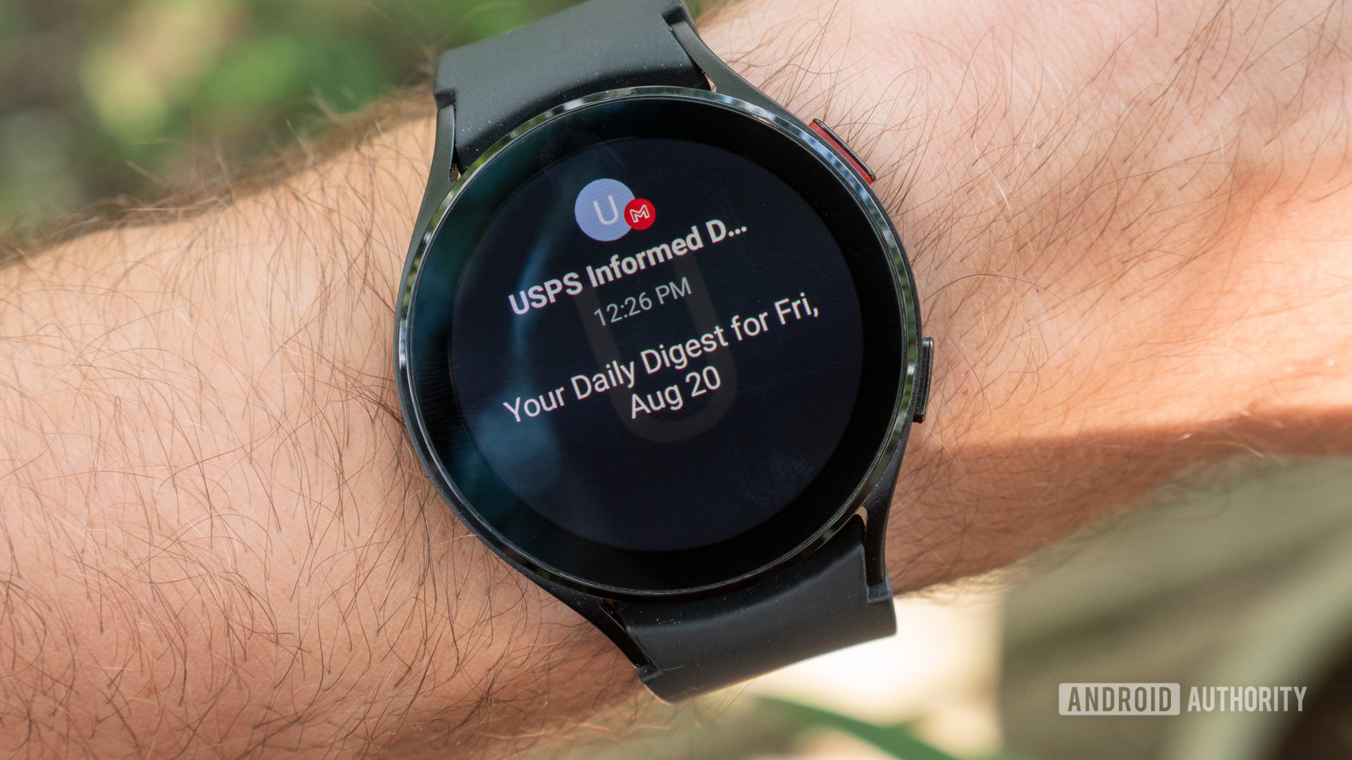 A Samsung Galaxy Watch 4 on a user's wrist shows a Gmail notification.