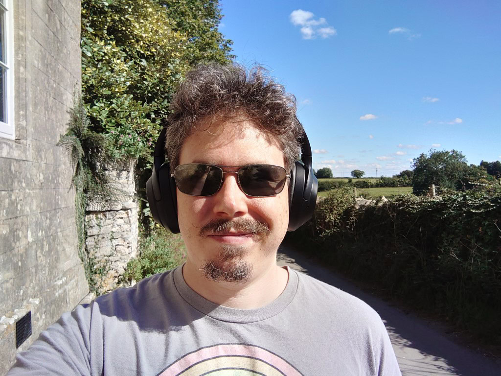 Sony Xperia 5 III camera sample selfie of a man with curly hair and a beard, wearing headphones and shades outdoors