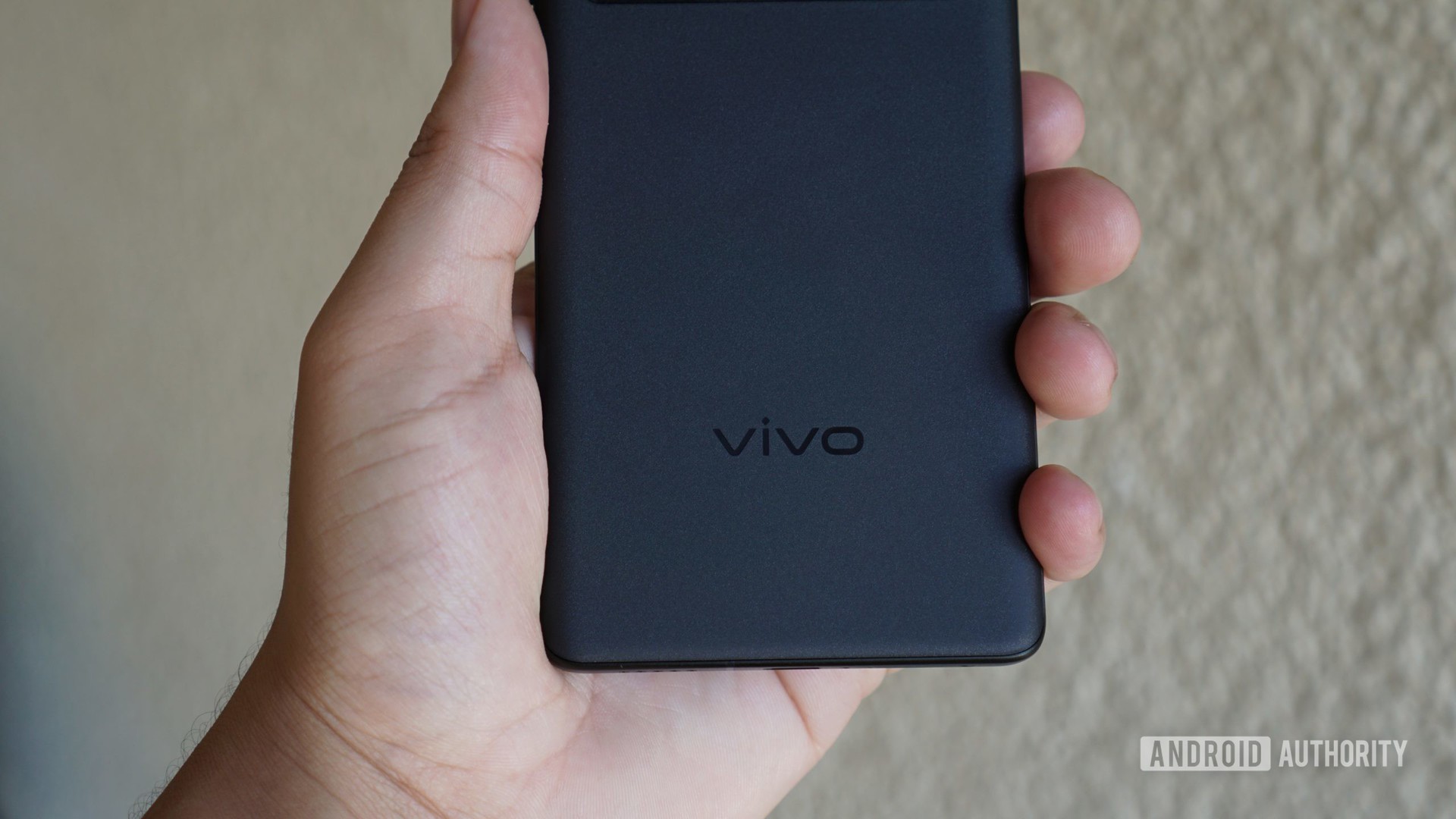 The Vivo logo on the X70 Pro Plus in hand.