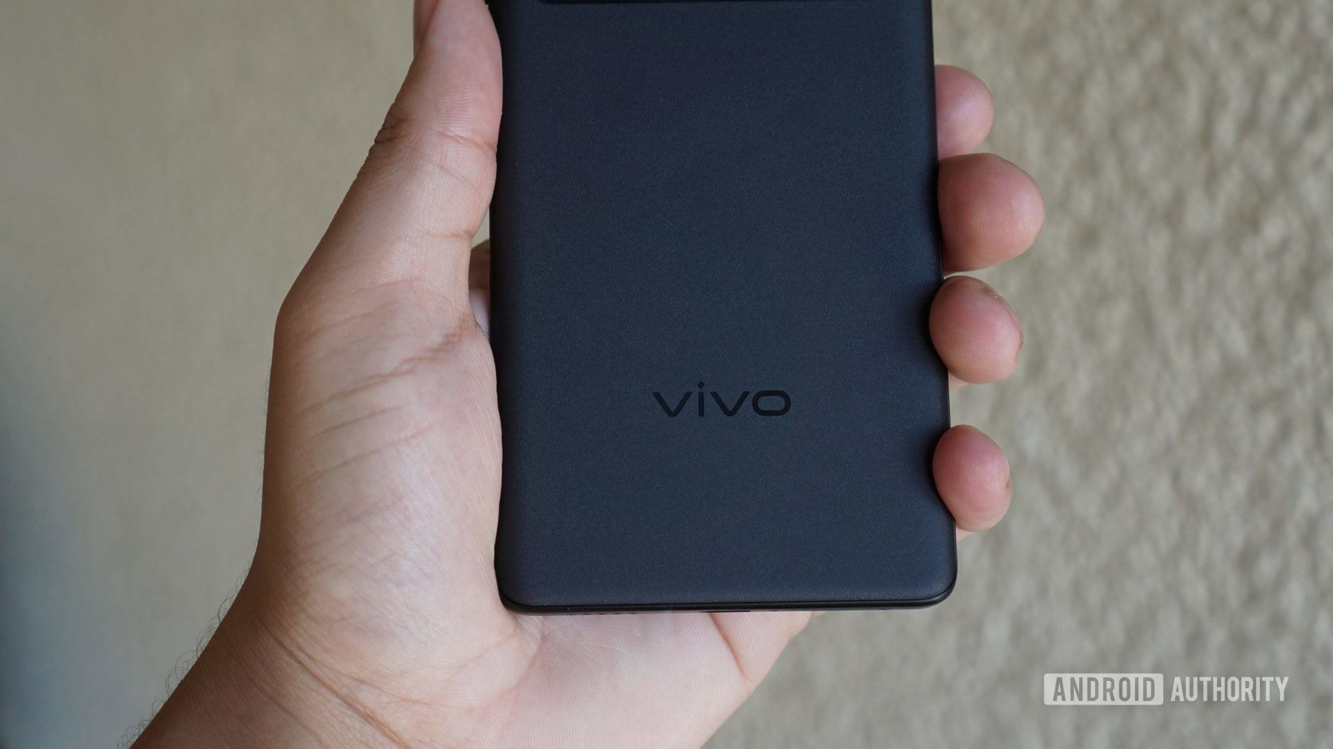 The vivo logo on the X70 Pro Plus in hand.