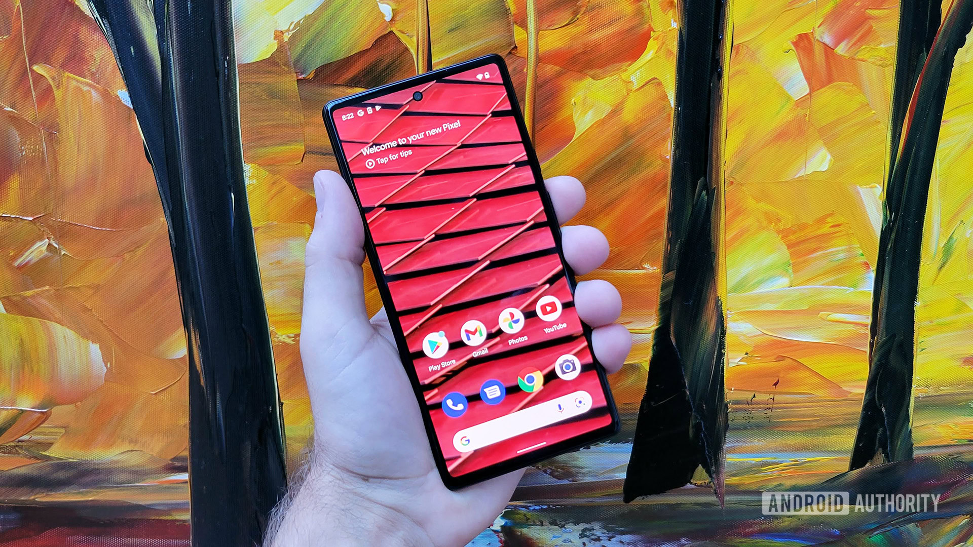 Google Pixel 6 in hand with red home scren