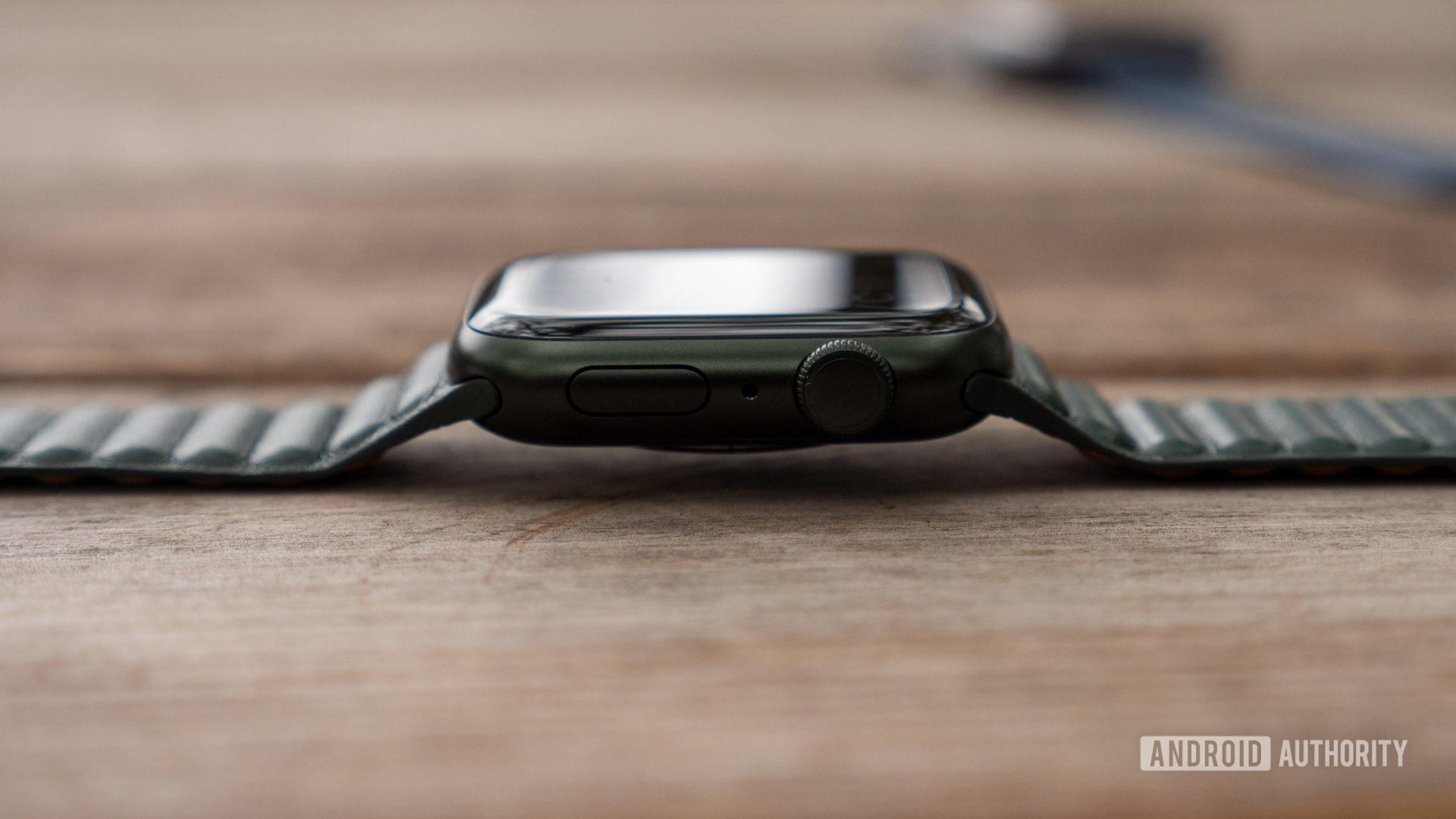 An Apple wearable rests on its side on a table, highlighting its Digital Crown.