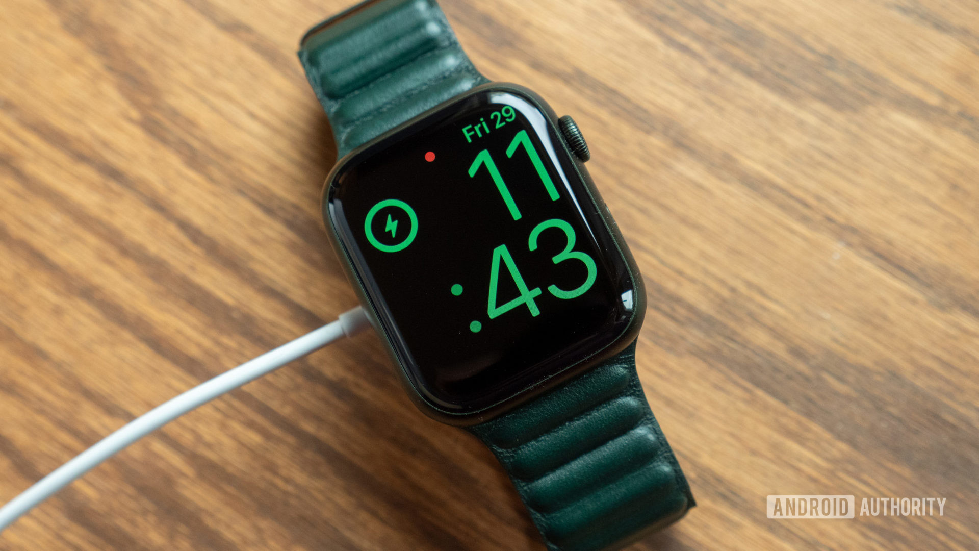 Apple Watch Series 7 rests on a table while charging.