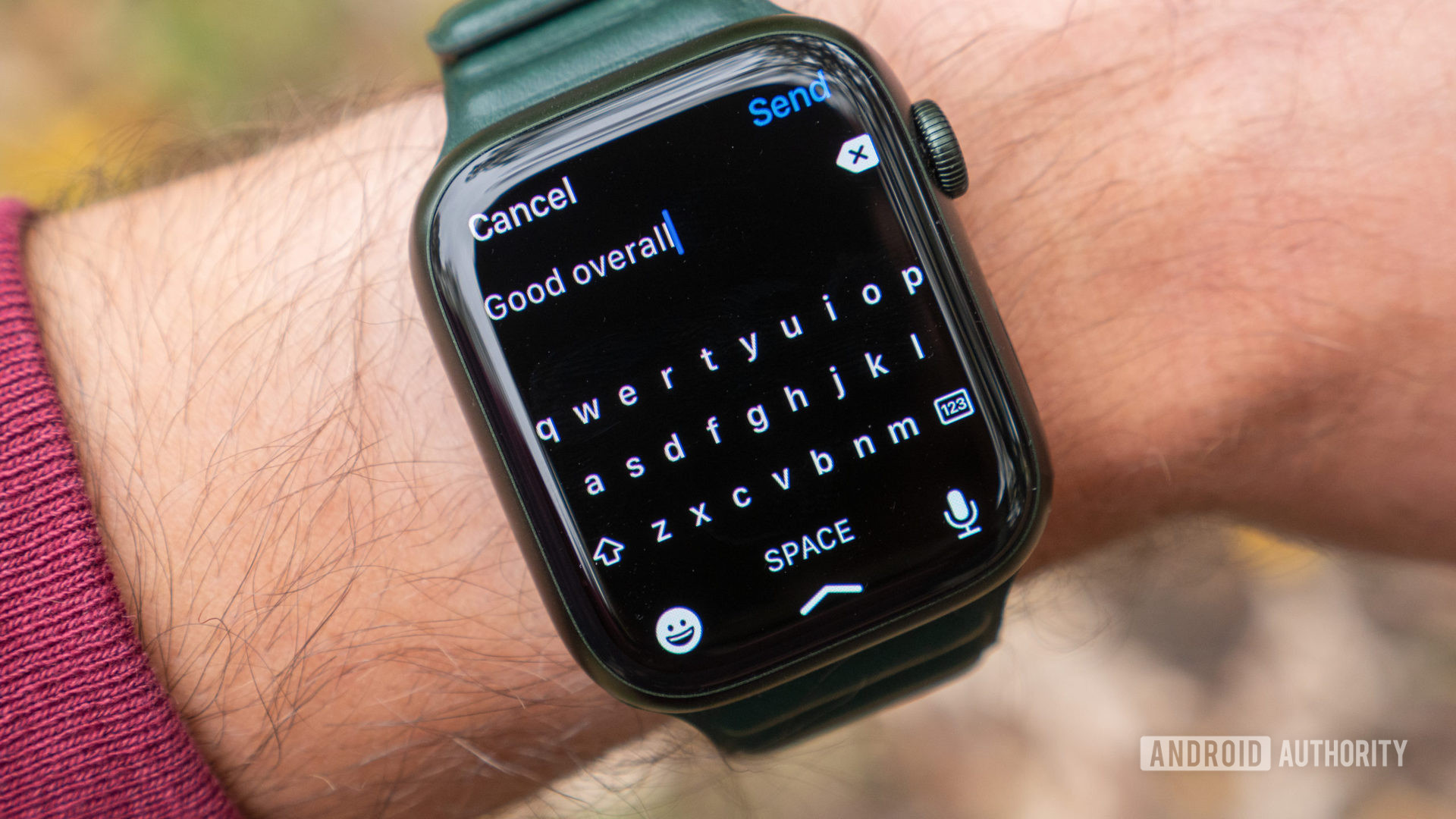 An image of the Apple Watch Series 7 on a wrist showing the on-screen keyboard in watchOS 8