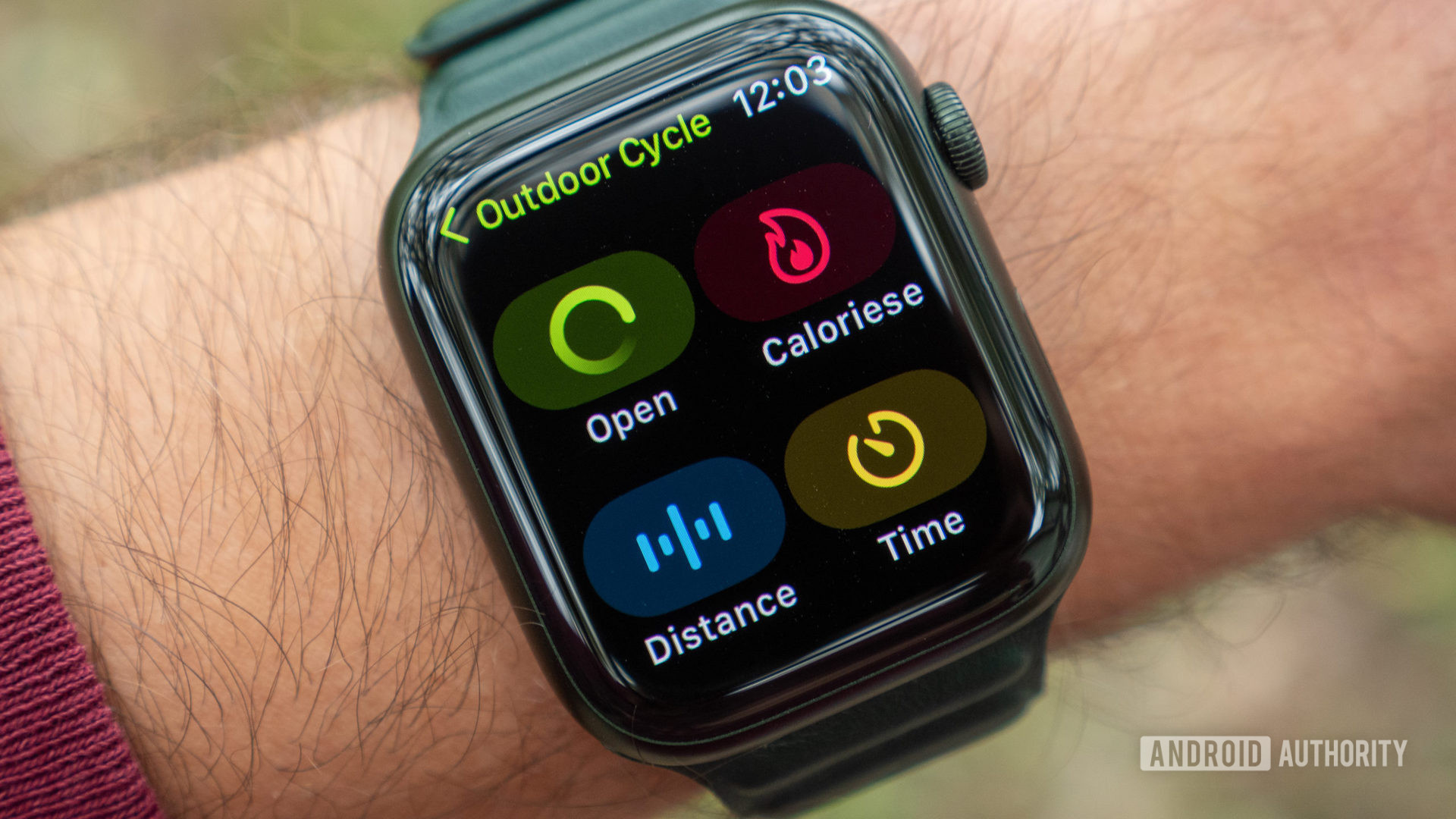 An Apple Watch Series 7 on a user's wrist displays the outdoor cycling settings screen.