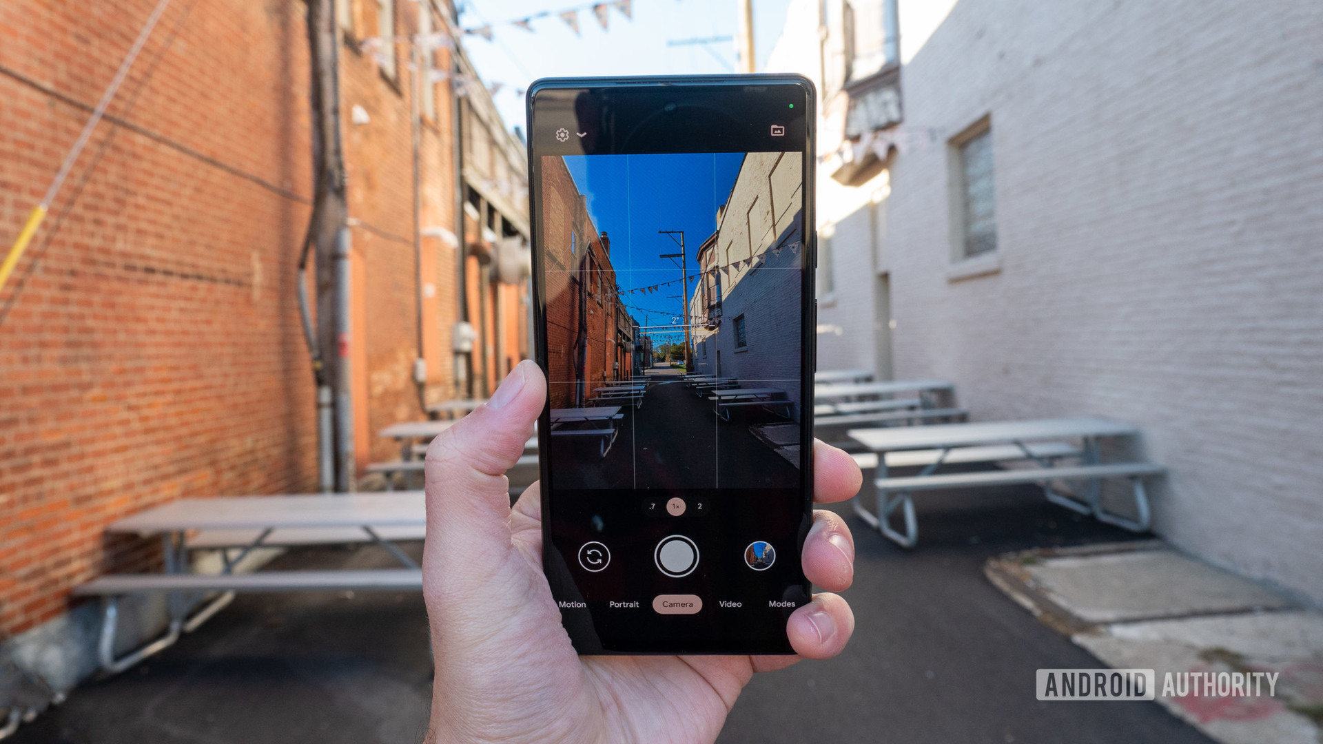 The Google Pixel 6 in hand in the alley showing the camera app