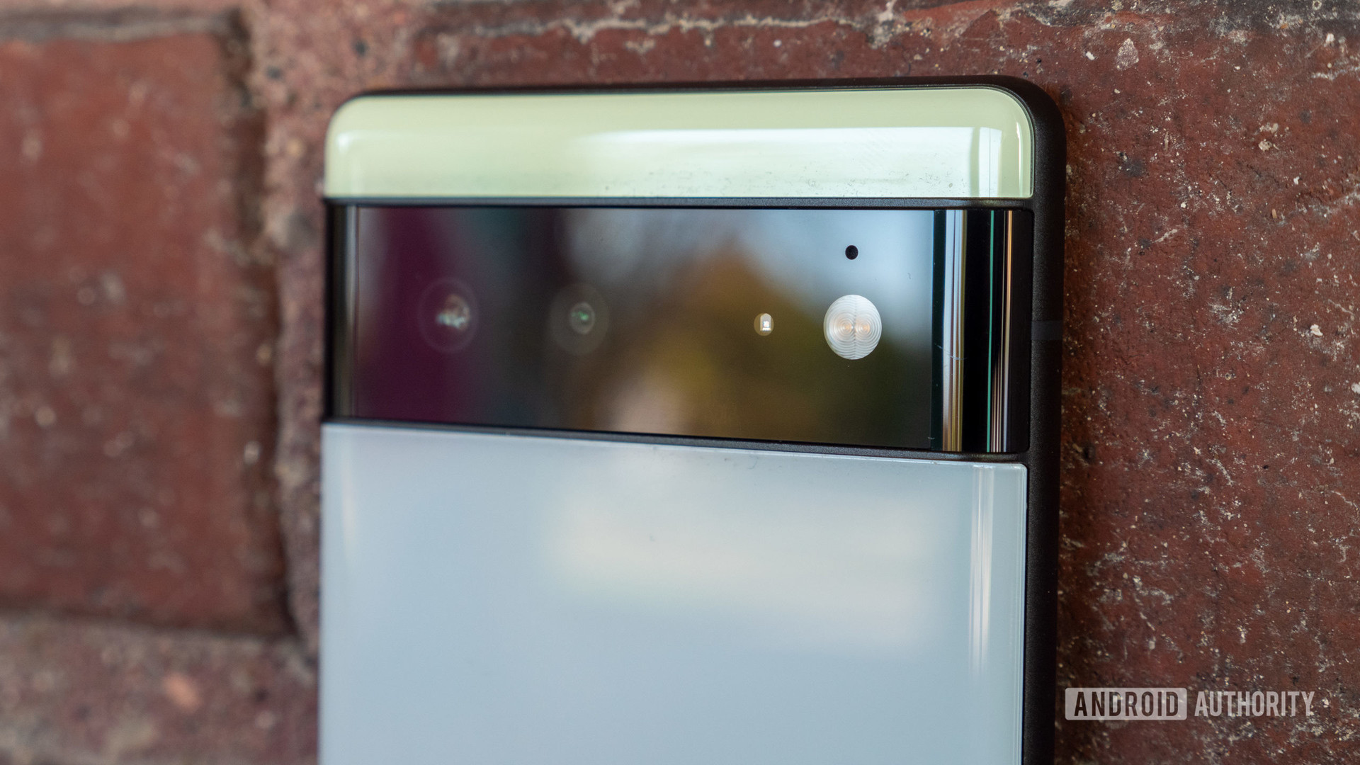Le Google Pixel 6 dans la barre de caméra couleur Sorta Seafoam de près contre la brique