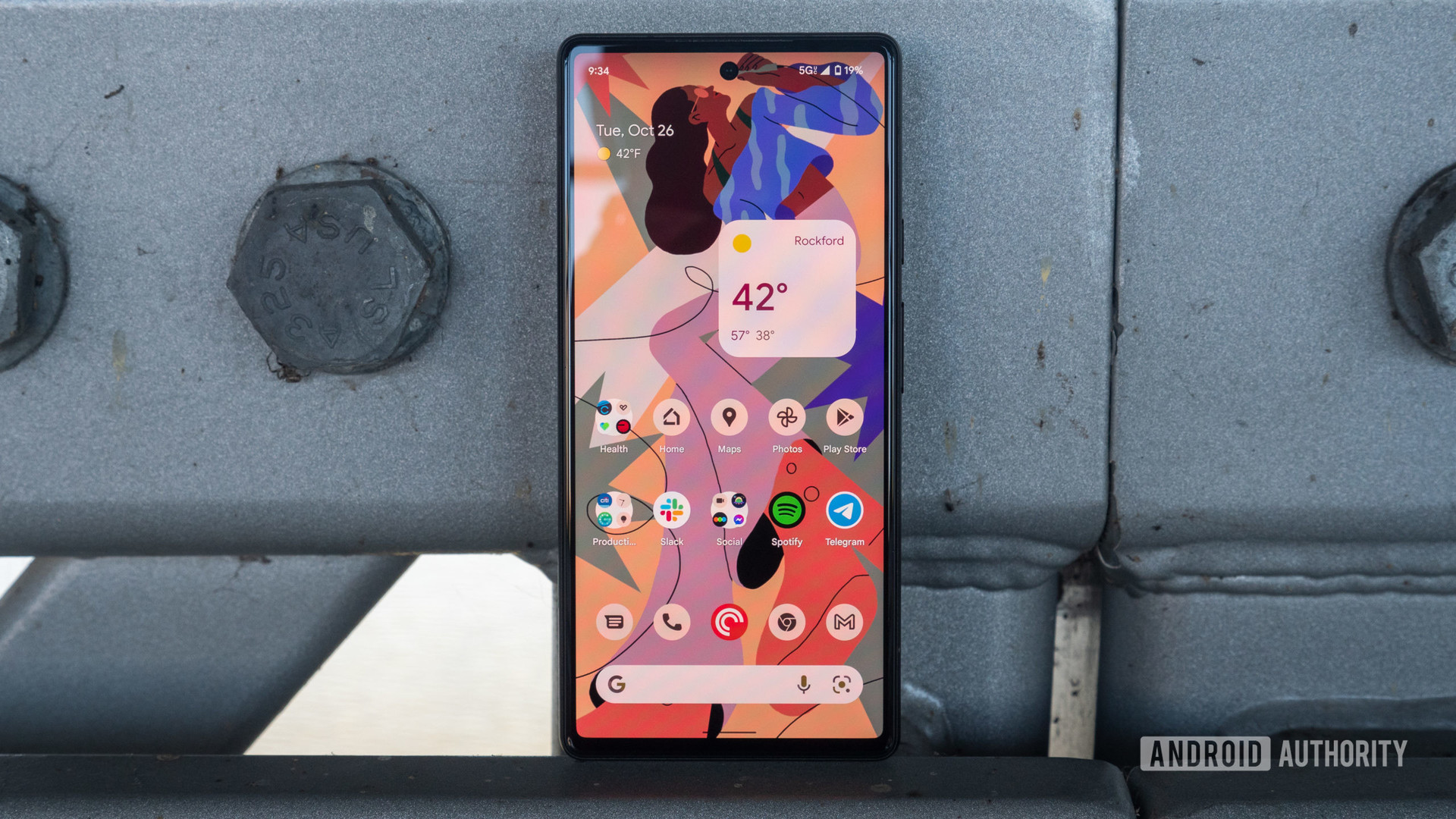 The Google Pixel 6 leans against a bridge, showing the home screen and display up close