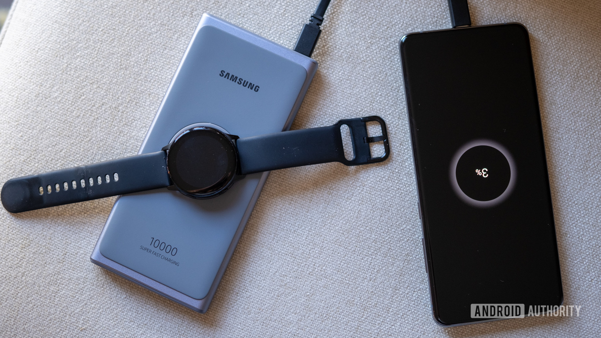 A top down image of the Samsung Super Fast power bank charging a Galaxy Watch Active and a Galaxy S20 Ultra