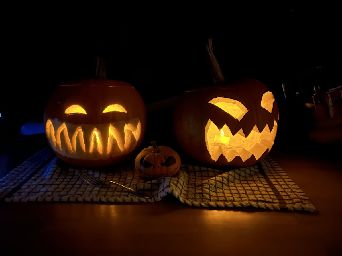 Camerasample dark shot of two carved pumpkins with candles inside in Night Mode Apple iPhone 13 Pro Max