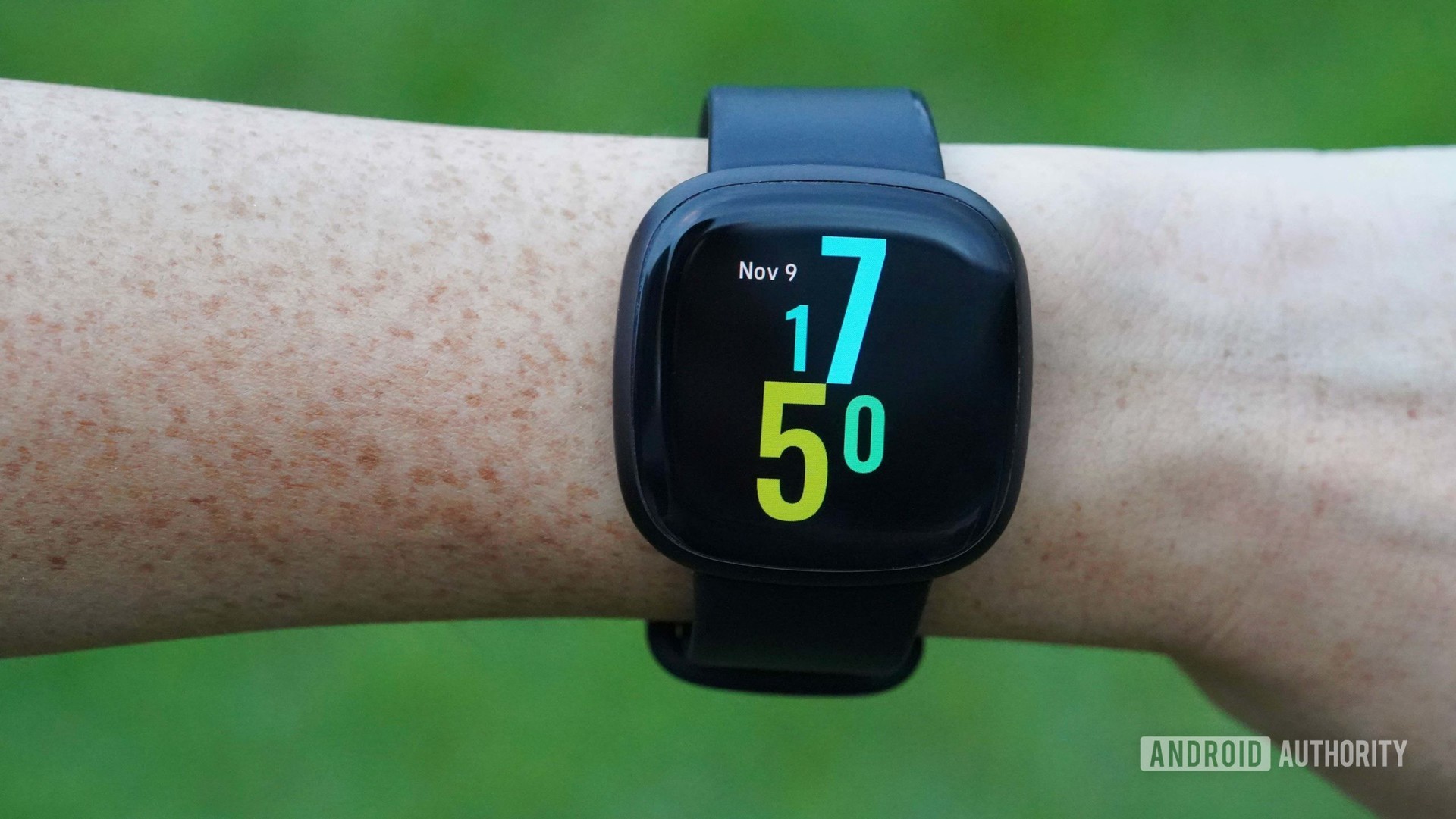 A Fitbit Versa 3 on a woman's wrist, showing the Hawaiian Punch watch face.