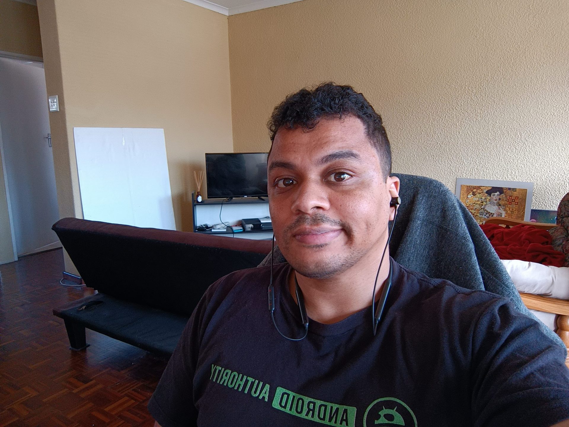 Poco M4 Pro selfie camera shot of a man with short dark hair wearing a dark colored Android Authority t-shirt