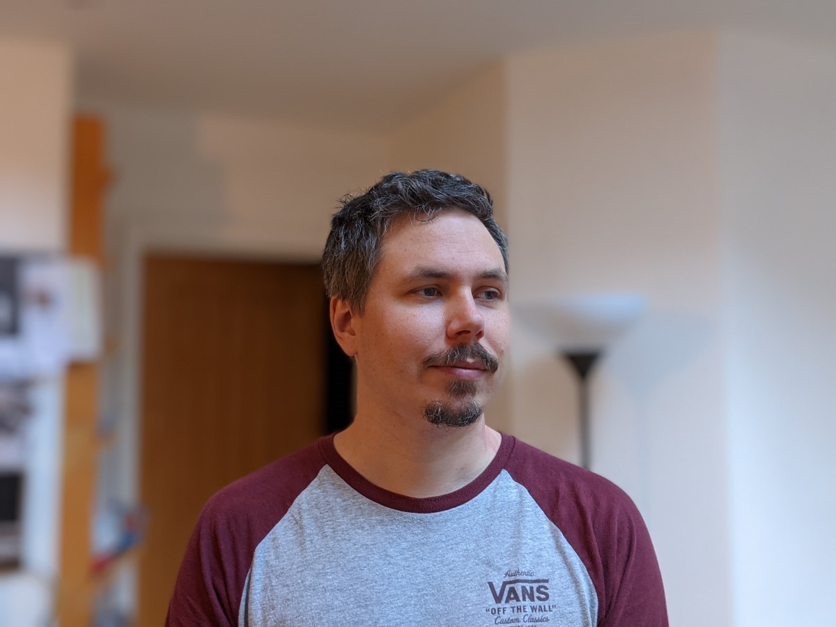 Pixel 5 portrait indoors of man wearing a grey and red shirt