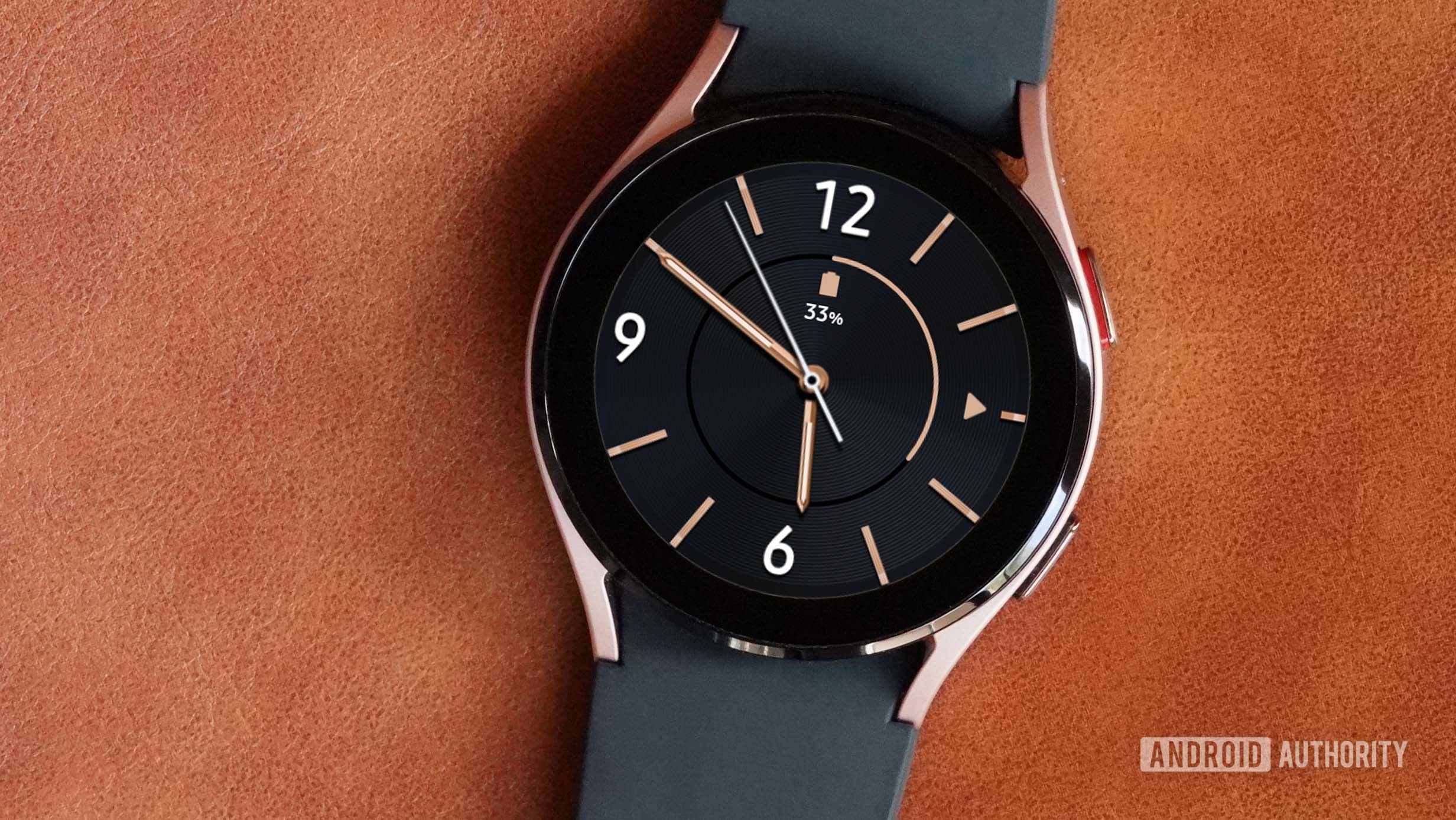 A Samsung Galaxy Watch 4 rests on a tan leather surface and displays the Modern Minimalist watch face.