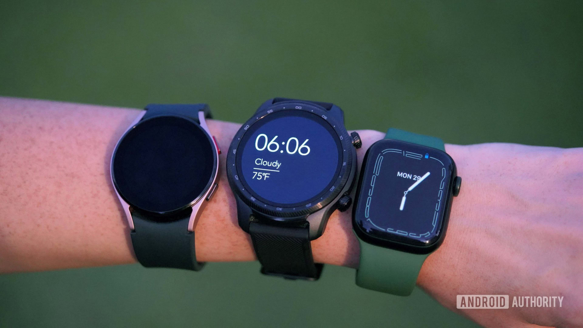 A woman wears a Mobvoi TicWatch Pro 3 Ultra, a Galaxy Watch 4, and an Apple Watch 7, all on the same wrist.