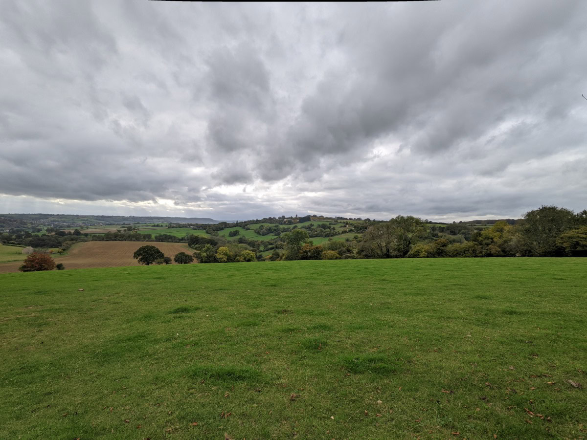 Wide angle picture of a grassy valley and overcast sky shot on Google Pixel 5