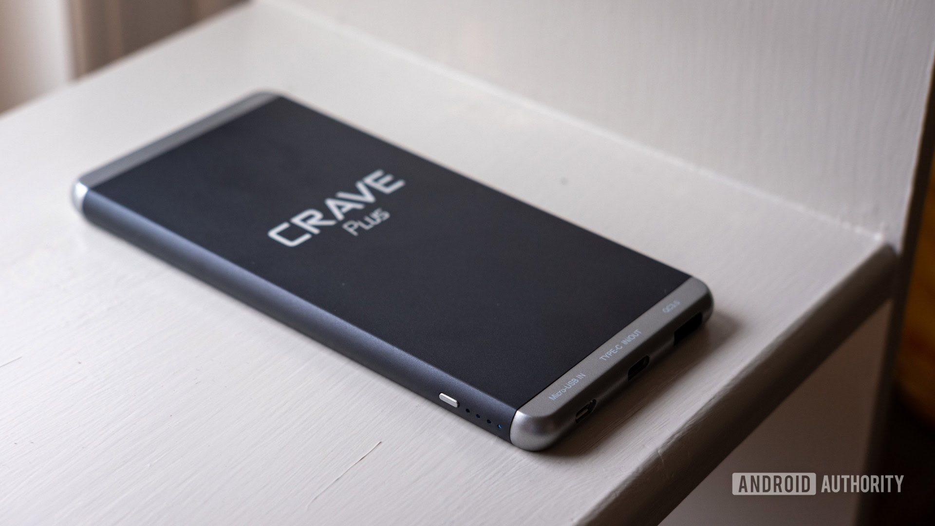 The Crave Plus external battery on a white shelf