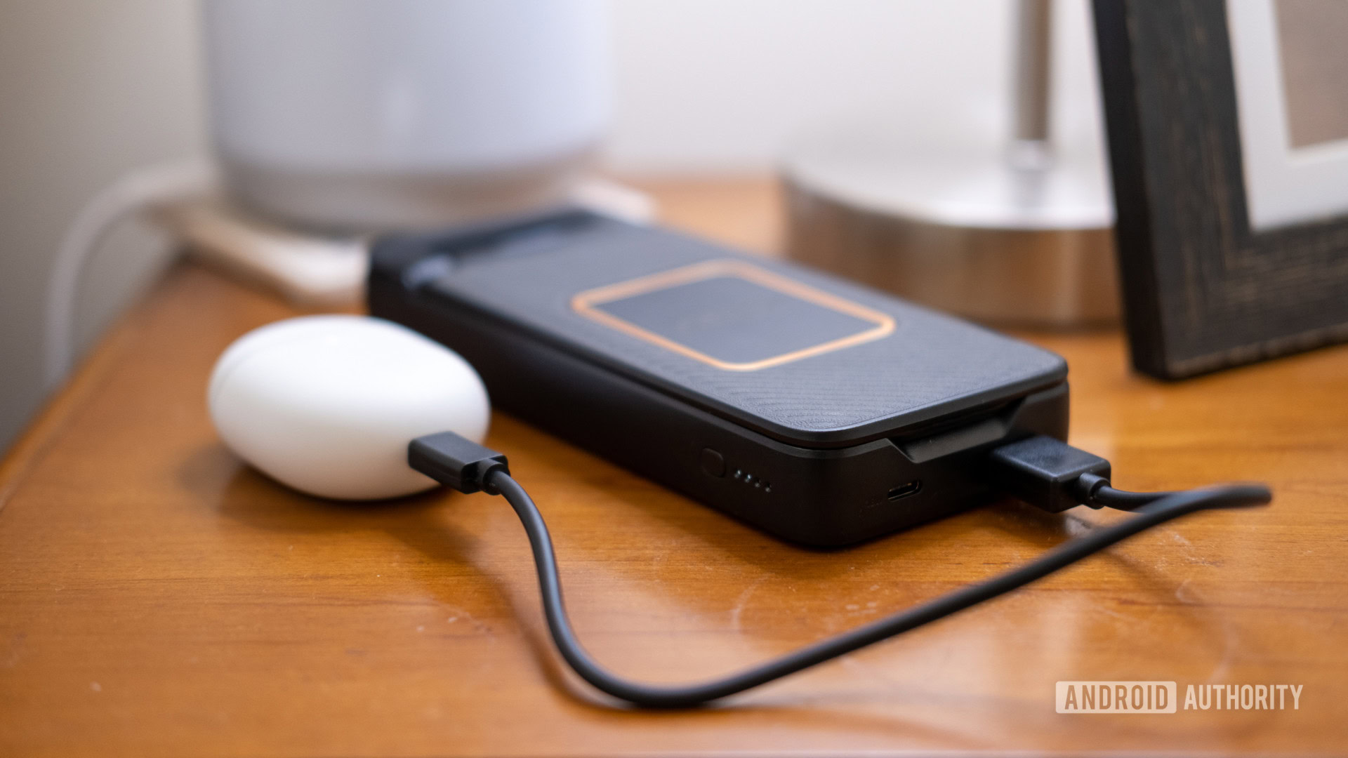 Otterbox Folding Wireless Power Bank on table showing ports and charging Pixel Buds