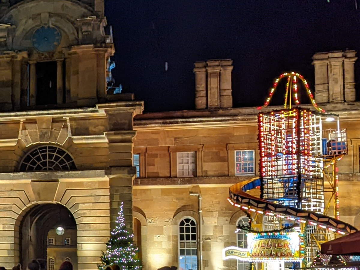 Crop of lit up stone building and fairground ride at night shot on Google Pixel 6 Pro