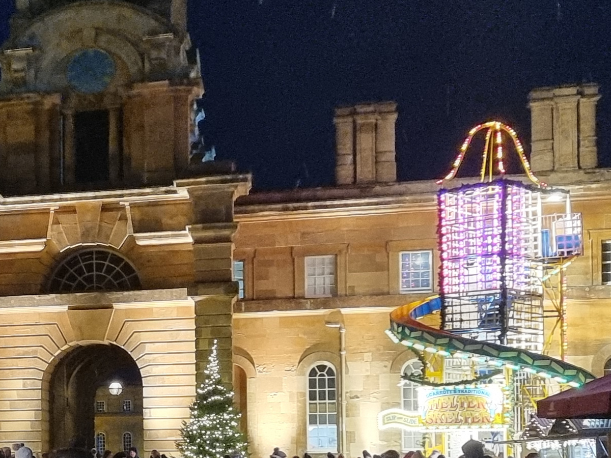 Crop of lit up stone building and fairground ride at night shot on Samsung Galaxy S21 Ultra